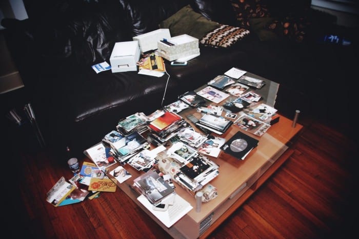 stacks of paper photographs all over a family room coffee table